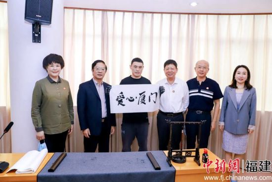 残障人士代表现场书写毛笔字“爱心厦门”。 残障人士代表现场书写毛笔字“爱心厦门”。